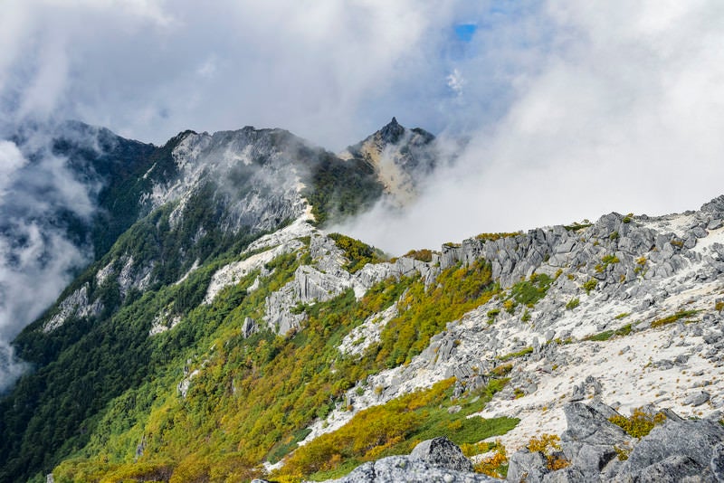 白砂の稜線の向こうに浮かぶオベリスク（鳳凰三山）の写真