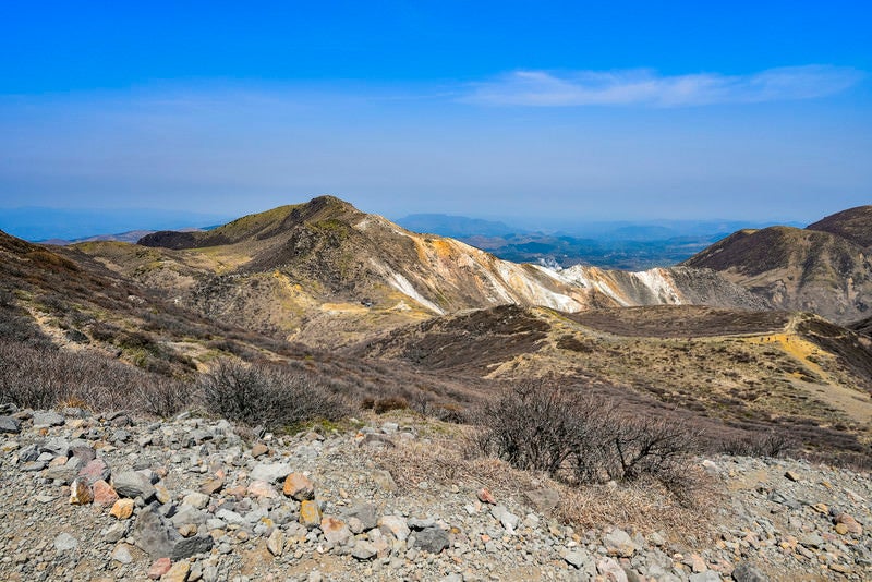 岩と枯れ木の春の久住山（くじゅうさん）の写真