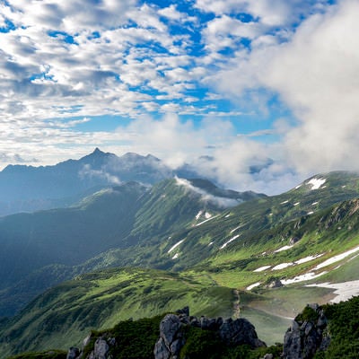 朝日に照らされる双六山荘方面とシルエットの槍ヶ岳（水晶岳）の写真