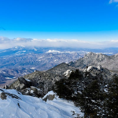 冬の瑞牆山と雲に覆われた八ヶ岳の遠景（金峰山）の写真