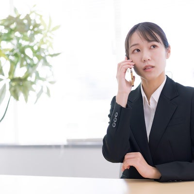 至急の電話を受ける女性の写真