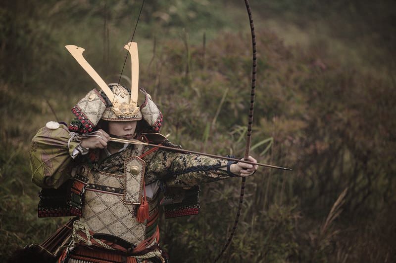 大弓で狙いを定める侍の写真