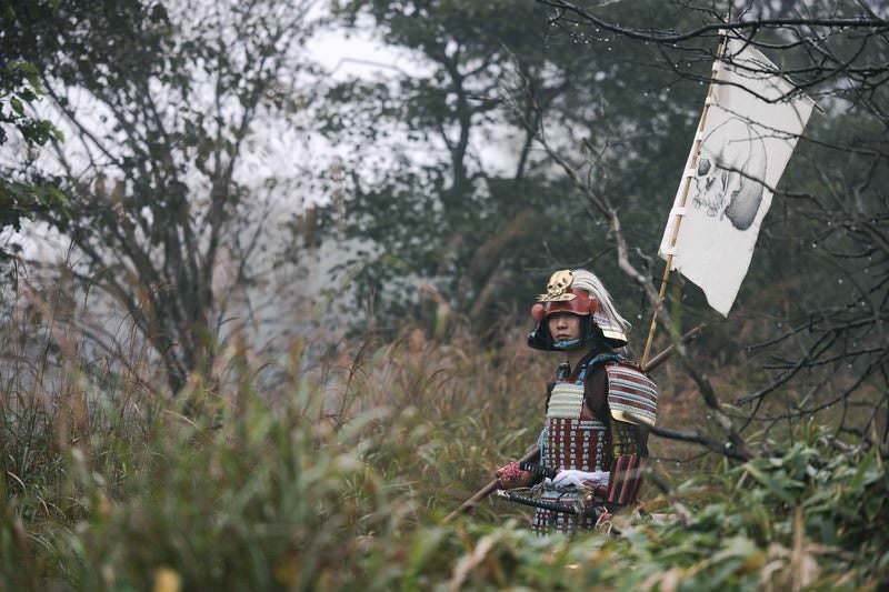 周囲を警戒する指物を背負った武士の写真