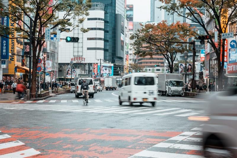 秋の渋谷スクランブル交差点付近（108付近）を行き交う車両の写真