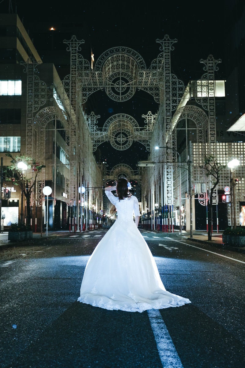 小雨が降る点灯前の神戸ルミナリエとドレスの女性の写真