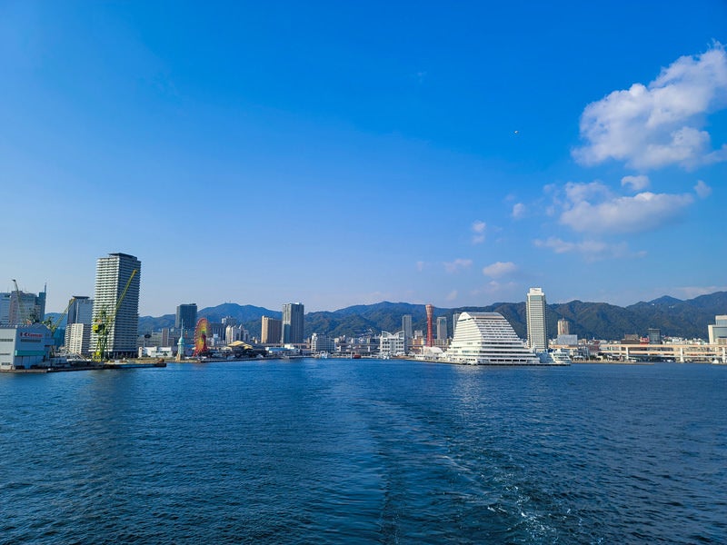 海面の航跡と遠景の港の写真