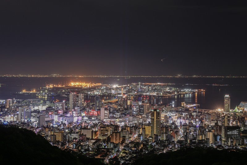 遠くに見る都市の夜景と港の写真