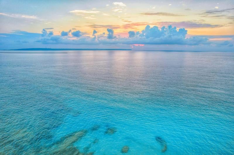 日暮れのオレンジの空と静かな宮古島の海の写真