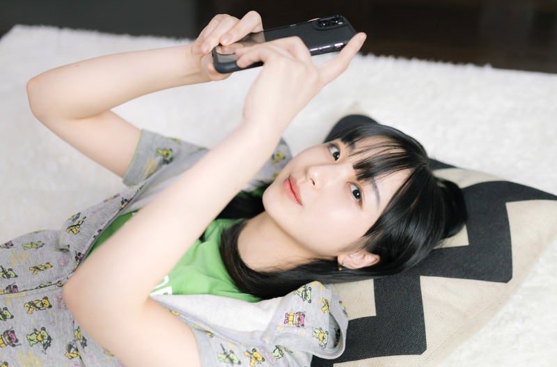 横たわるスマホ女子の写真