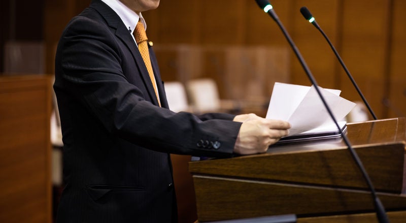 議会で演説する議員の写真