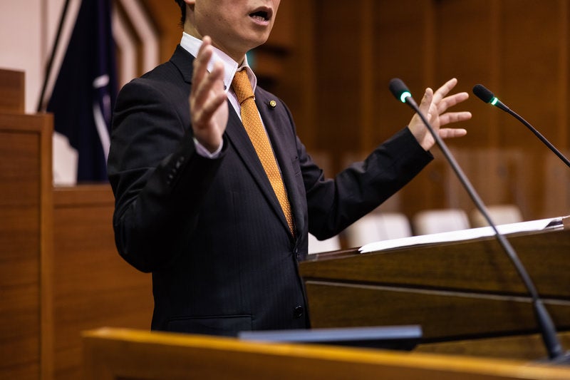 議会中、議論が非常に激しくなり激しくジェスチャーをする様子の写真