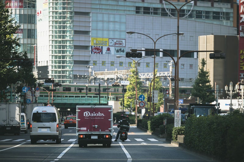 信号で停まる車両とバイクの写真