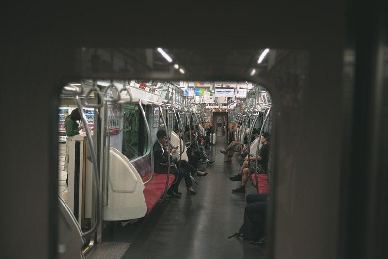 隣の車両から覗く電車内の様子の写真