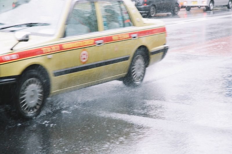 大雨で大忙しのタクシーの写真