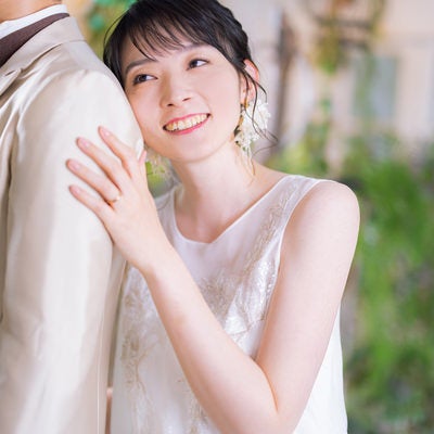 彼の背中に寄り掛かる幸せそうな顔をする新婦の写真