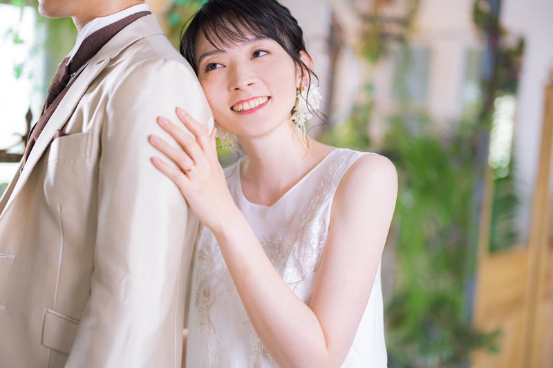 彼の背中に寄り掛かる幸せそうな顔をする新婦の写真