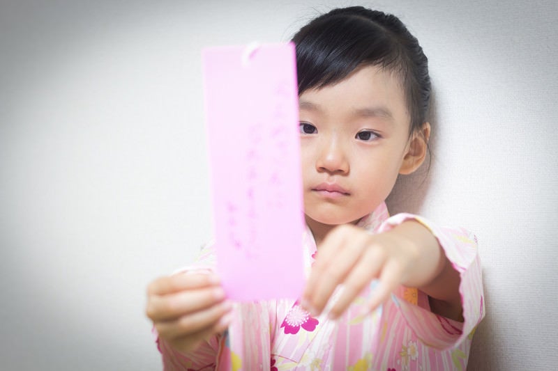 願い事を書いた短冊が不満な女の子の写真