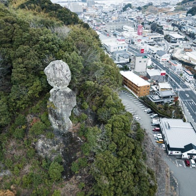 車通りが多い街中にある落ちそうな巨岩（鯖くさらかし岩）の写真