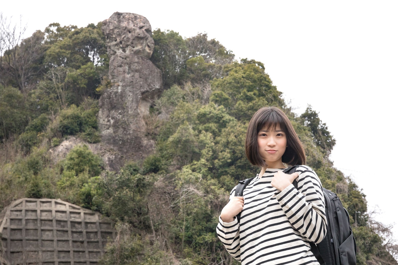 「鯖くさらかし岩とページを探す女性」の写真［モデル：塩田みう］