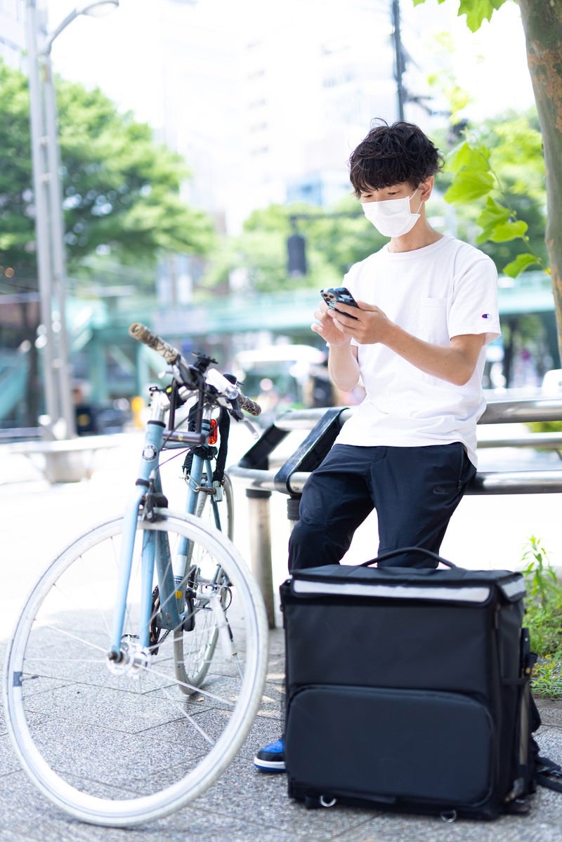 配達依頼を受ける配達員の男性の写真