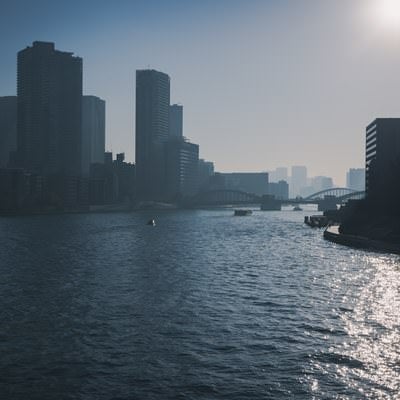 霞みゆくビル群へと続く海の写真