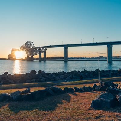 ゲートブリッジの下に入り込む夕日の写真