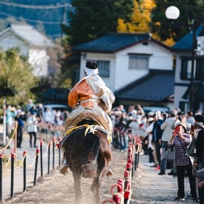 走り抜ける流鏑馬と観客の写真