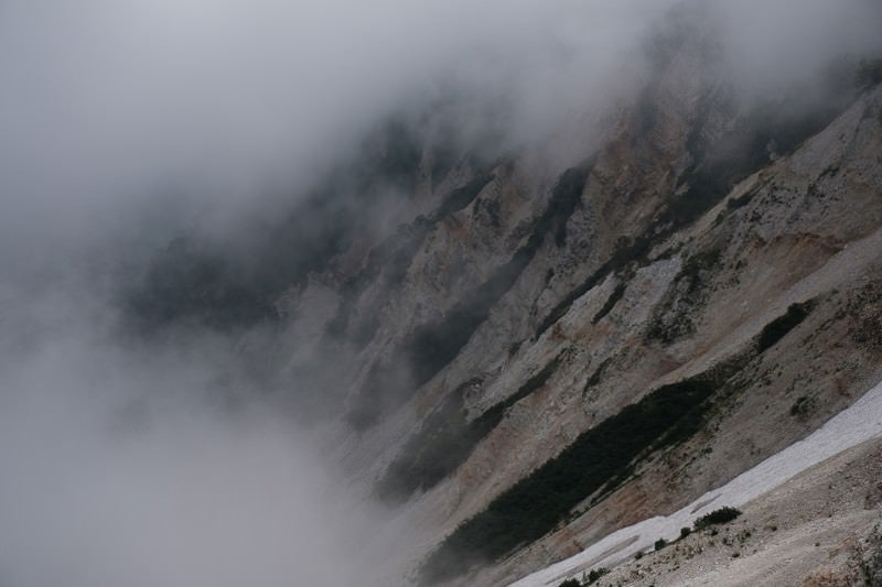 ガスに包まれた傾斜の山肌（白馬岳）の写真