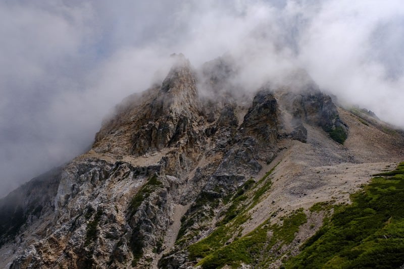 沸き立つガスに包まれた岩山（白馬岳）の写真