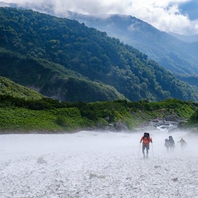 吹き下ろす冷風の白馬大雪渓を登る登山者達（白馬岳）の写真