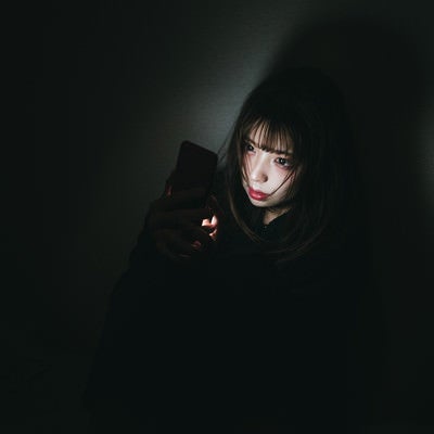 返事が来なくて深夜になってもスマホをチェックしてしまう女性の写真