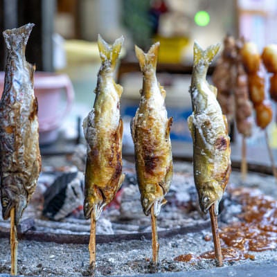 串にささった鮎の塩焼きの写真