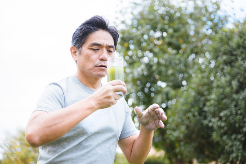 青汁の苦さに驚きを隠せない中年男性の写真