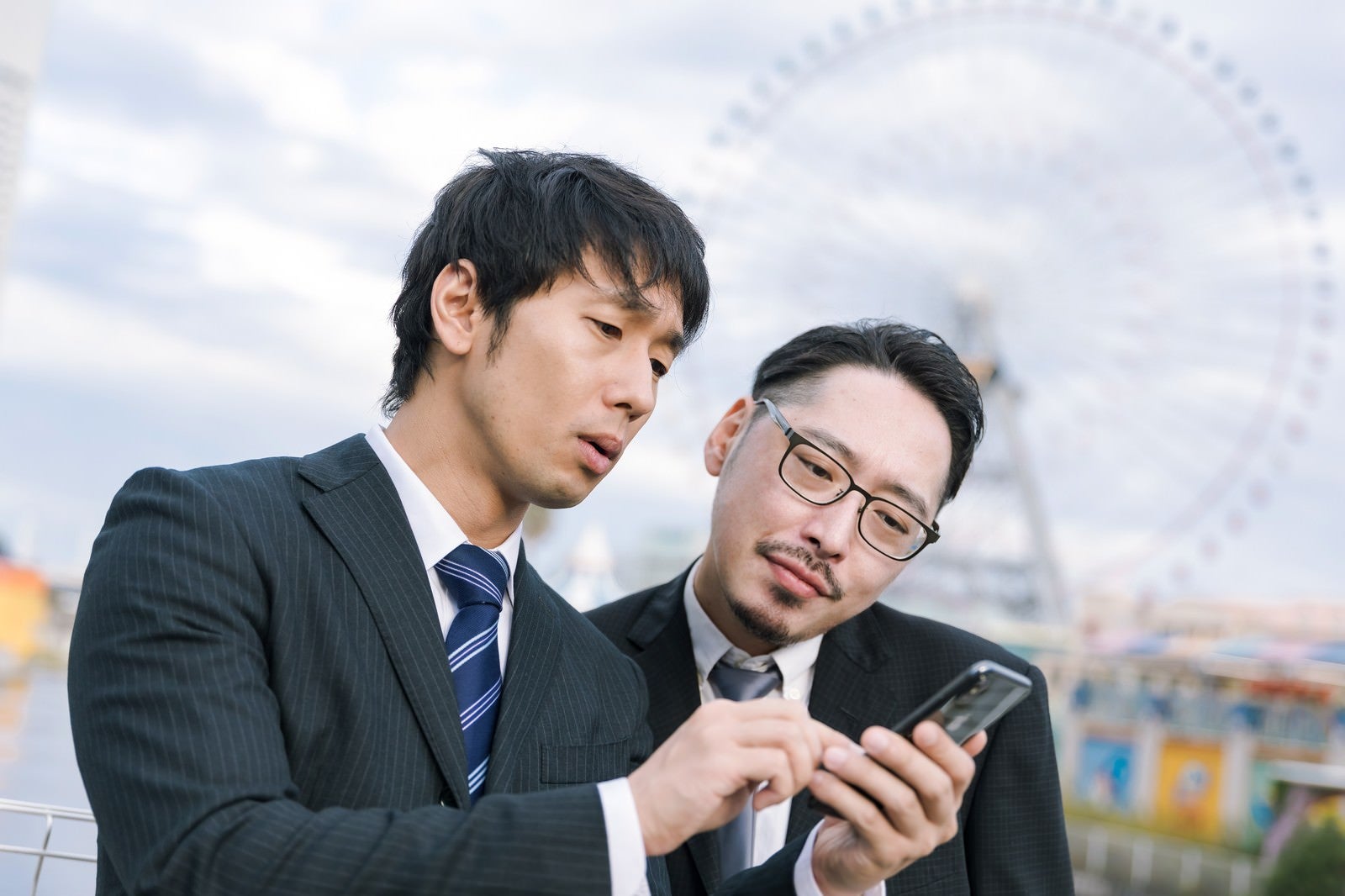 「訪問先の住所を調べる営業マン」の写真［モデル：大川竜弥 ゆうせい］