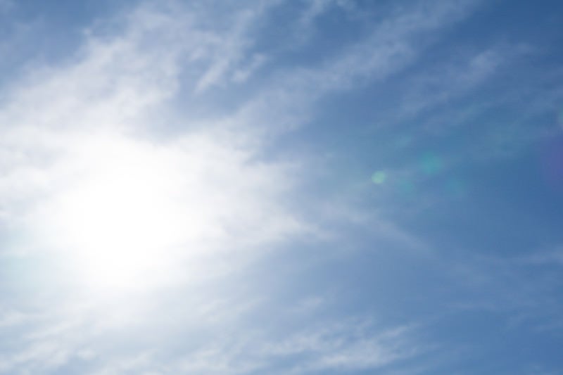 薄雲に隠された太陽と筋状の雲の写真