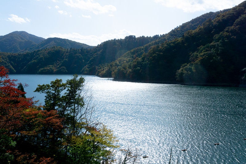 日に照らされた輝くさざ波に彩られた徳山湖の写真