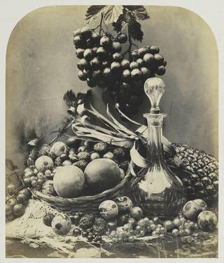 Still life showing a partially full decanter and a fruitbowl