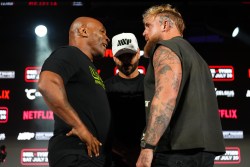 ARLINGTON, TEXAS - MAY 16: (L-R) Mike Tyson, Nakisa Bidarian and Jake Paul pose onstage during the Jake Paul vs. Mike Tyson Boxing match Arlington press conference at Texas Live! on May 16, 2024 in Arlington, Texas.  (Photo by Cooper Neill/Getty Images for Netflix)