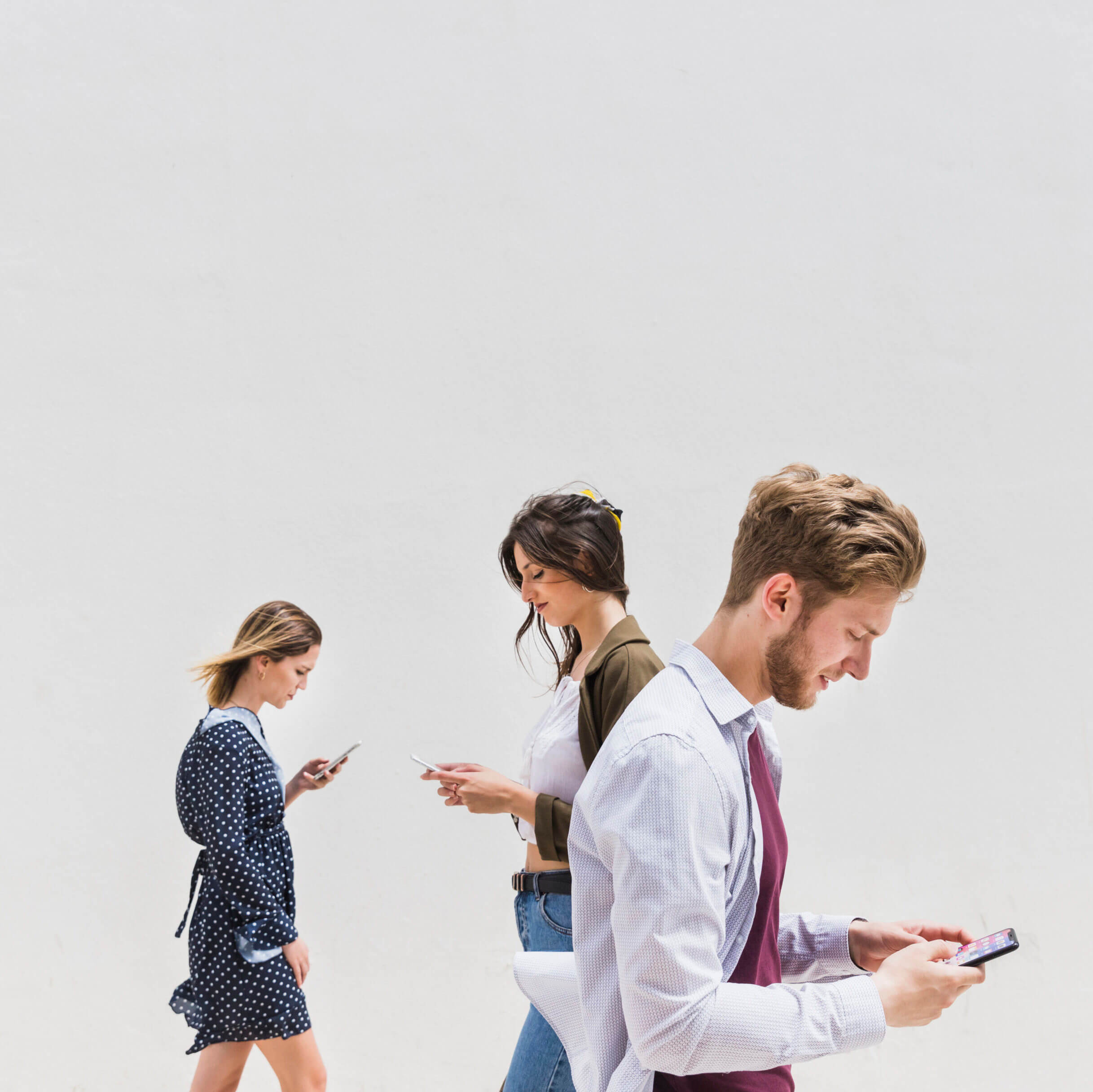 three people walking against white background using mobile phone - Sales