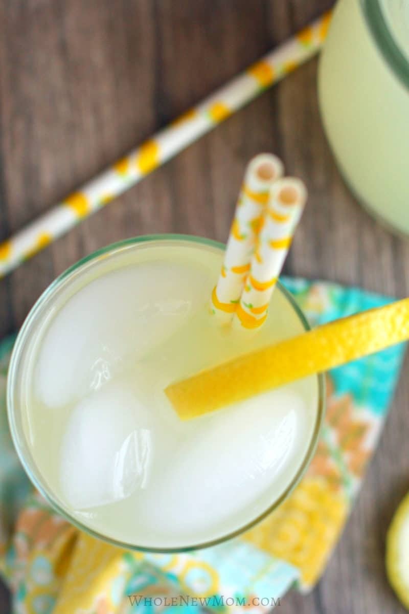 sugar-free lemonade in glass with lemon slice garnish and straws with lemons