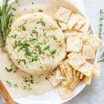 almond feta on a white plate with crackers