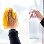 window cleaner in spray bottle pointed at the window