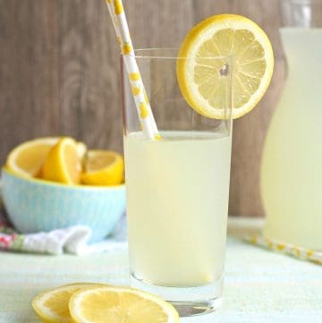 glass of lemonade with straw and garnished with lemon