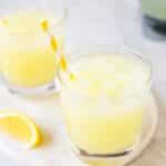 whole lemon lemonade in glass with straw.