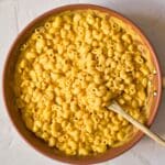 large bowl of gluten-free dairy-free mac and cheese with wooden serving spoon.