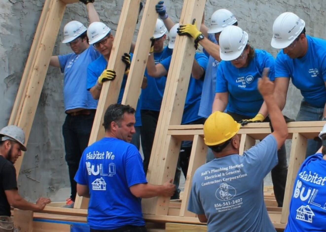 Habitat for Humanity volunteers raising a wall