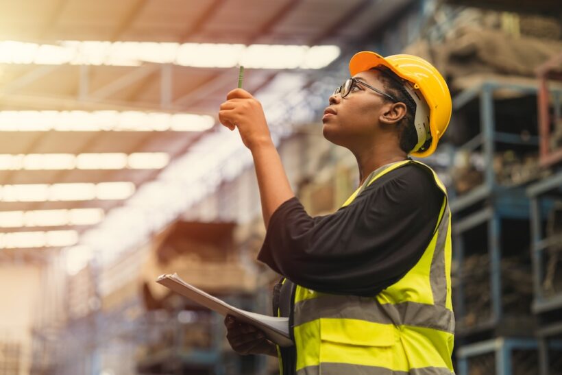 Black African professional women worker working count checking inventory production stock control in business factory industry warehouse waring engineer suit and helmet for safety