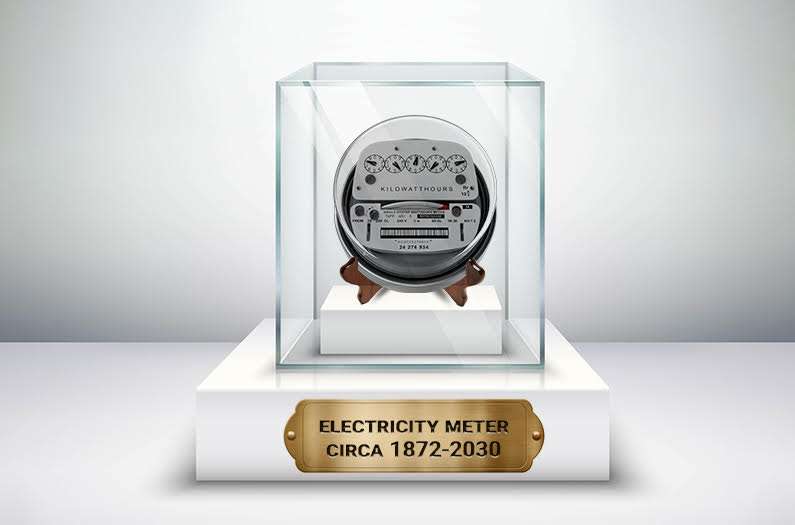 An electricity meter in a glass museum case, with the label "Circa 1872 to 2030"