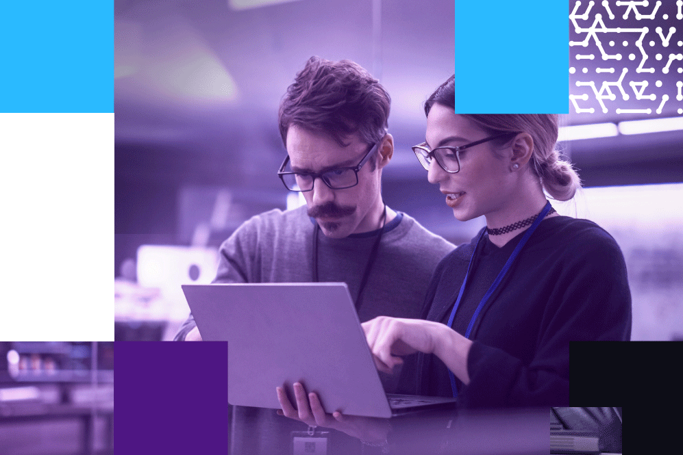 two coworkers looking at laptop in a lab