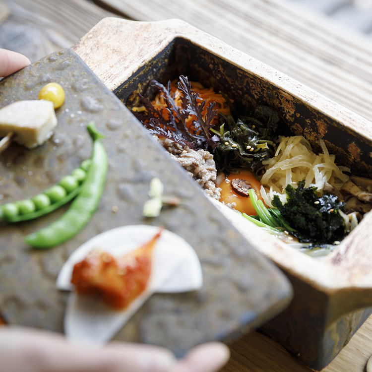 陶箱の中は、丹念に仕込まれた10種のナムル、目玉焼きがのせられたビビンパ。中でも「トラジ（キキョウの根）」という韓国野菜を使ったナムルが、ほろ苦くアクセントになる